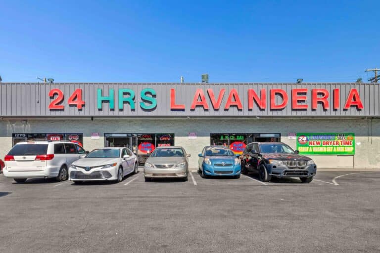 Parking lot in front of 24/7 laundry near USC with cars parked outside the building