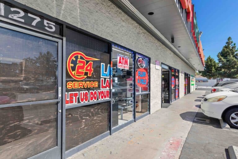 Storefront of 24/7 laundry near USC with signs displayed on the windows